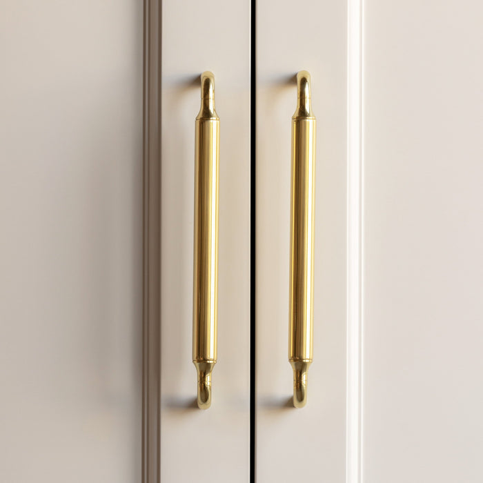 Beige cabinet with gold handles on a beige background